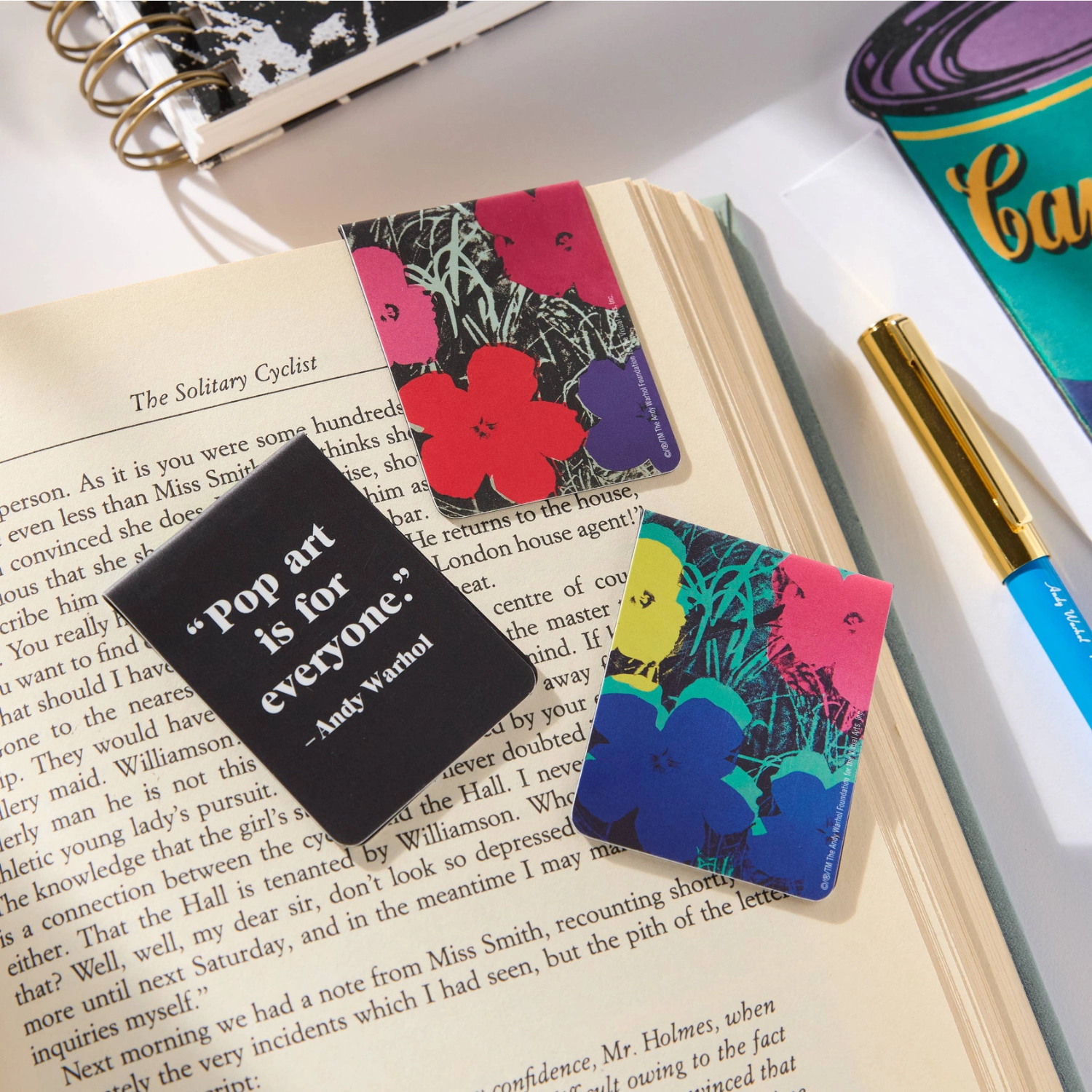 Colorful pop art bookmarks on a book with a pen and notebook in the background