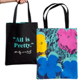Front and back of a tote bag, back with 'All is Pretty' text with Andy Warhol's signature and the front with pop art floral Flowers design, on a white background.