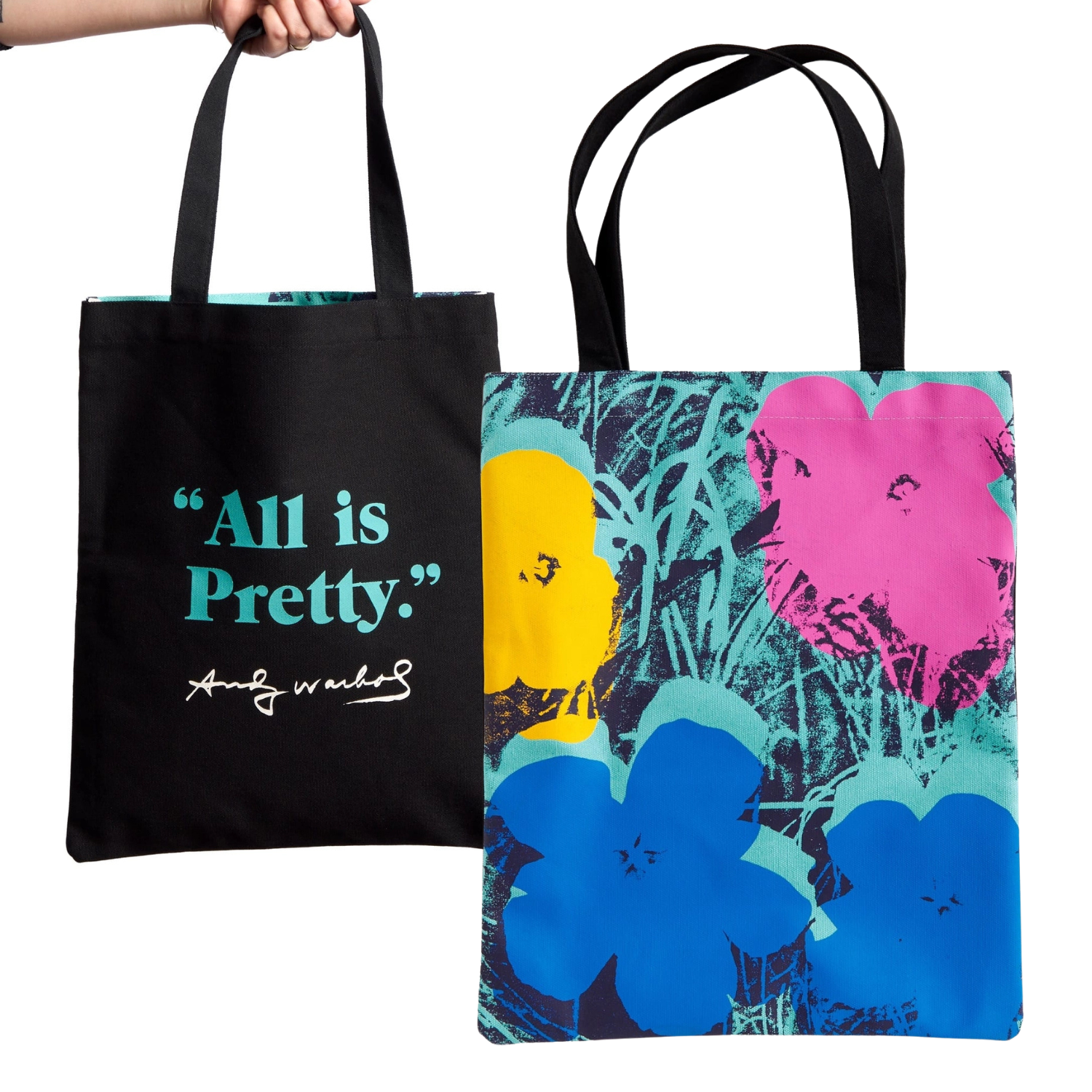 Front and back of a tote bag, back with 'All is Pretty' text with Andy Warhol's signature and the front with pop art floral Flowers design, on a white background.