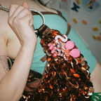 Person holding a decorative bag with sequins and pink rat keychain attached.