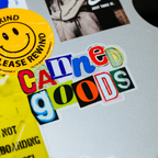 Colorful sticker with text and a smiley face on a textured surface