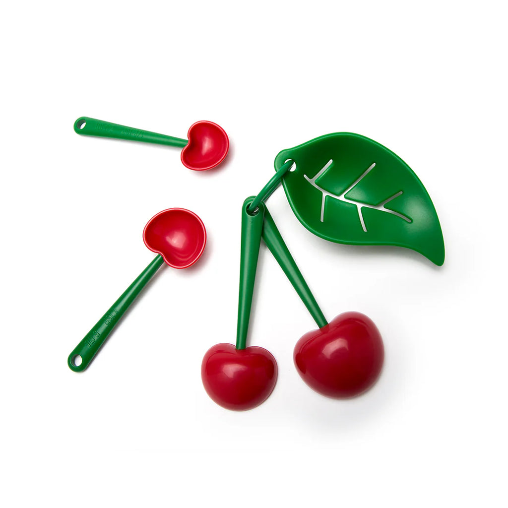 Cherry measuring spoon set separated from green leaf egg separator, showing individual measuring spoons for baking.