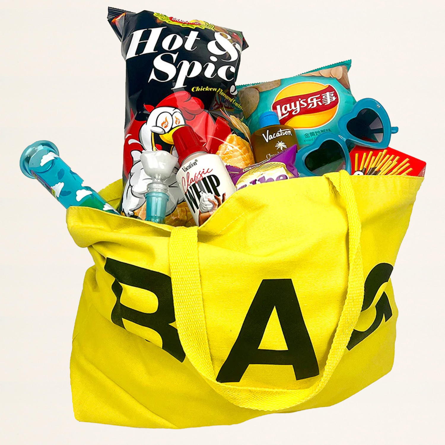 Yellow tote bag filled with snacks and toys on a white background
