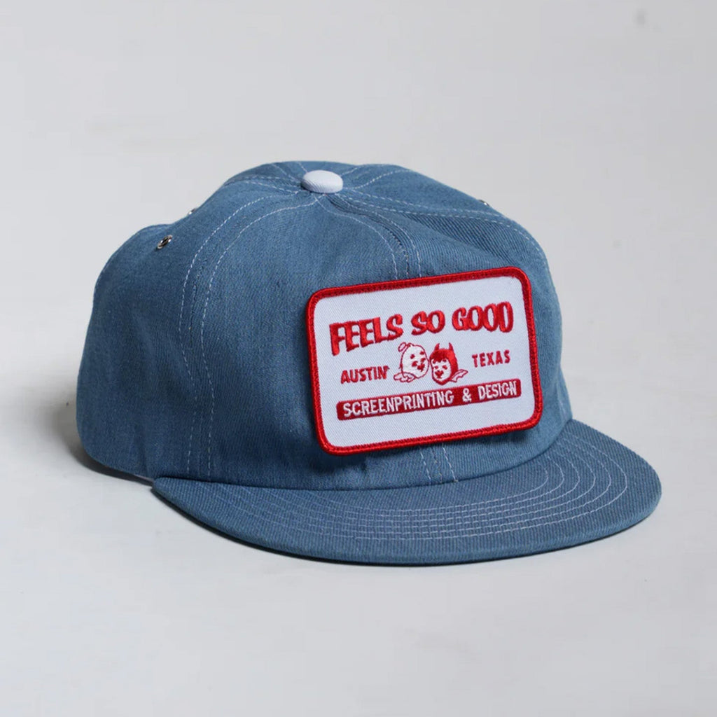 Blue denim cap with a red and white patch on a light gray background
