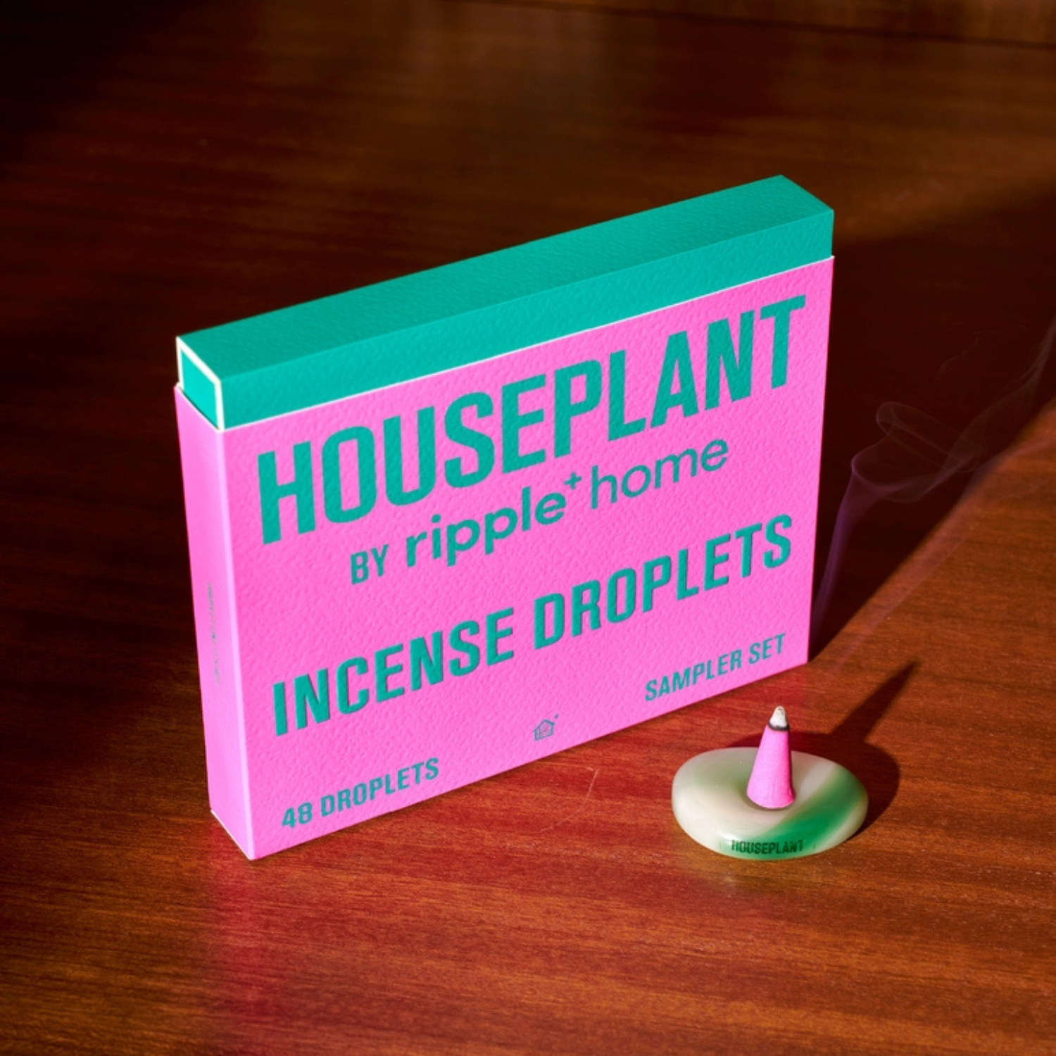 Pink and teal box of Houseplant by Ripple Home Incense Droplets on a wooden surface