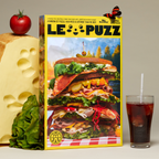 LE PUZZ puzzle box with a large sandwich illustration, surrounded by ingredients and a drink.