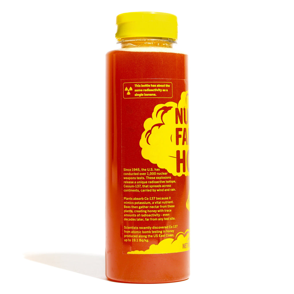 Honey bottle with a yellow cap and fact label on a white background
