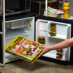Person holding a LE PUZZ puzzle box in front of an open refrigerator.