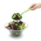 Monstera leaf serving spoon scooping fresh mixed greens into a salad bowl, a fun kitchen utensil for plant lovers and home cooks.