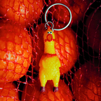 Yellow rubber chicken keychain on a red textured background