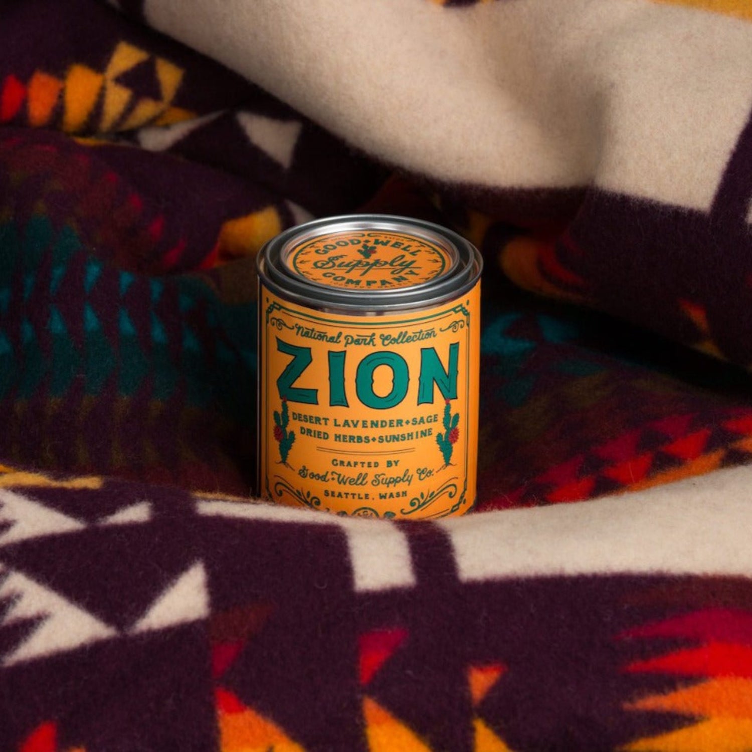 Zion candle canister on a patterned fabric background