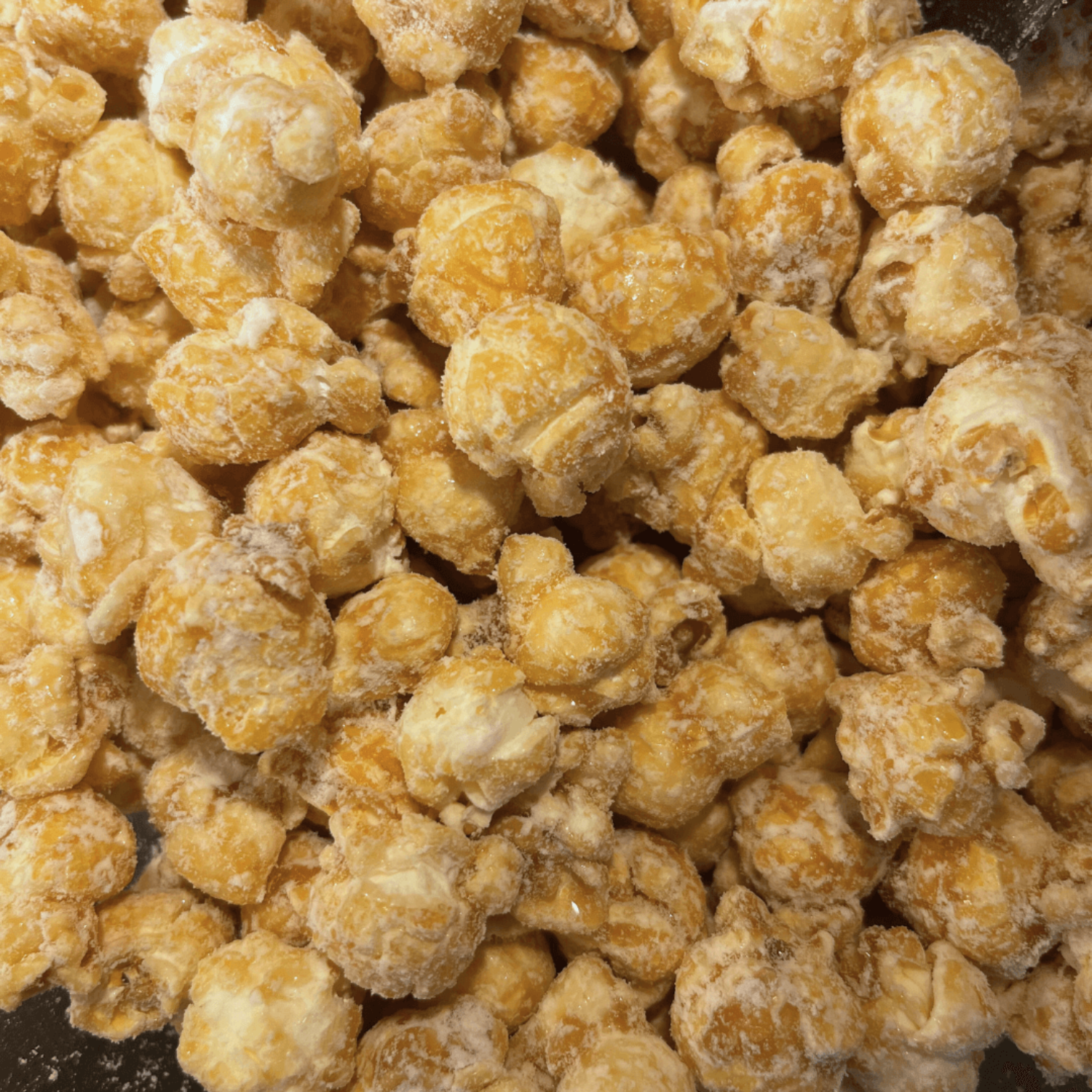 Close-up of a pile of white cheddar dusted caramel popcorn.