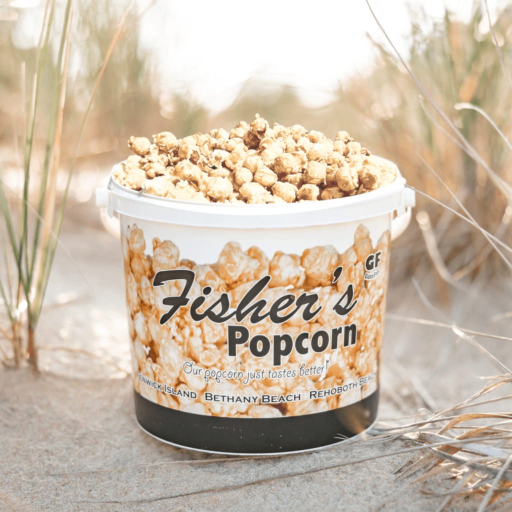 Container of Fisher's Popcorn on a sandy background