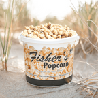 Container of Fisher's Popcorn on a sandy background